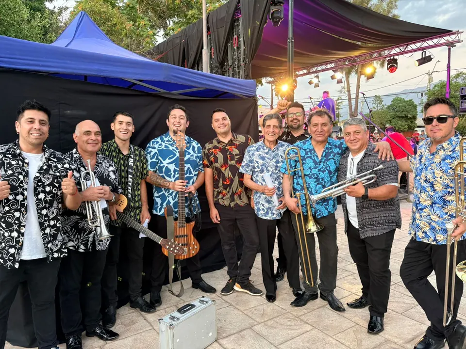 Los músicos de La Banda del Papi con camisas de estampado floral, en una foto grupal al aire libre